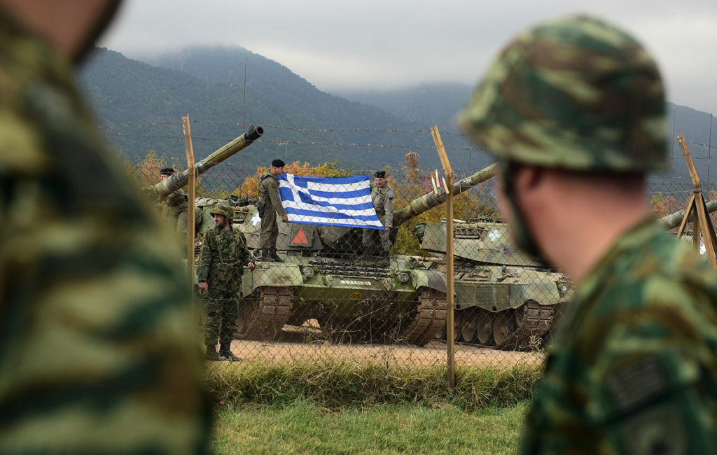 Στρατιώτες μπροστά από άρμα μάχης με ελληνική σημαία. Η στρατιωτική προετοιμασία που θα έπρεπε να γίνεται στην Ελλάδα...